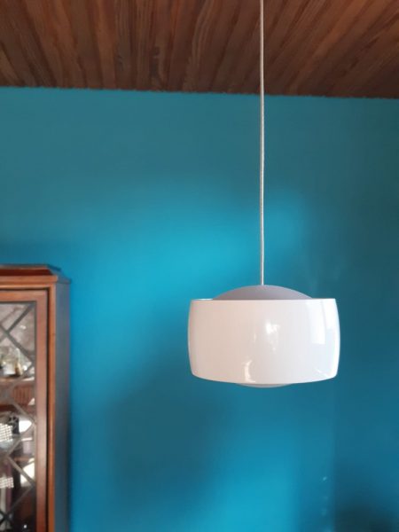 Moderne Deckenleuchte, dimmbar und mit Gestensteuerung vor einer farbigen Wand