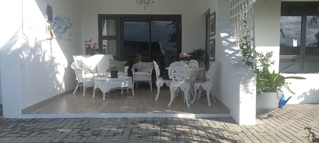 Sheltered verandah with various seating options, where many hours are spent reading or entertaining friends.
