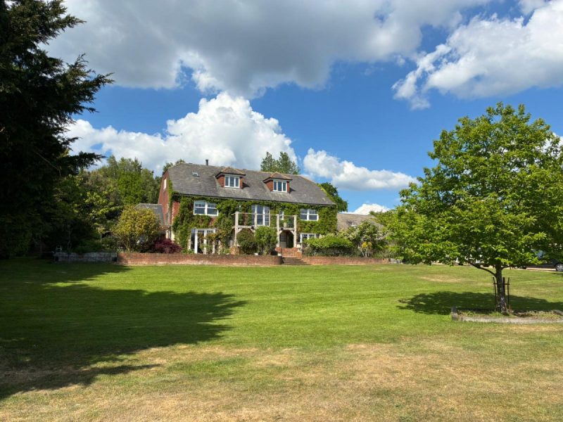 Photo of the green house facade in the summer months viewed from the garden
