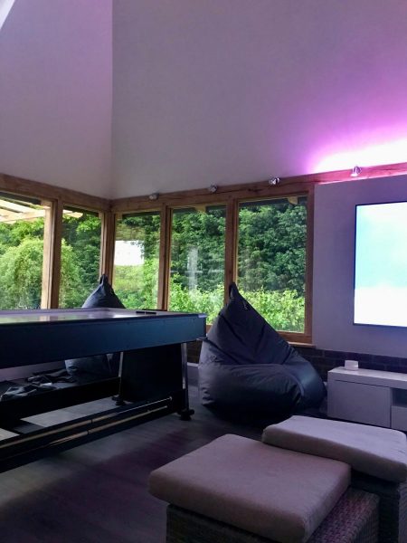 Photo showing the large windows of the games room facing onto the lush greenery beyond