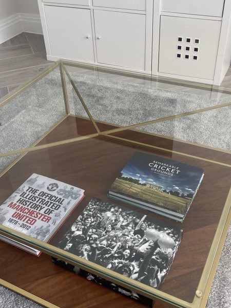 Photo of a glass coffe table with books placed at the bottom