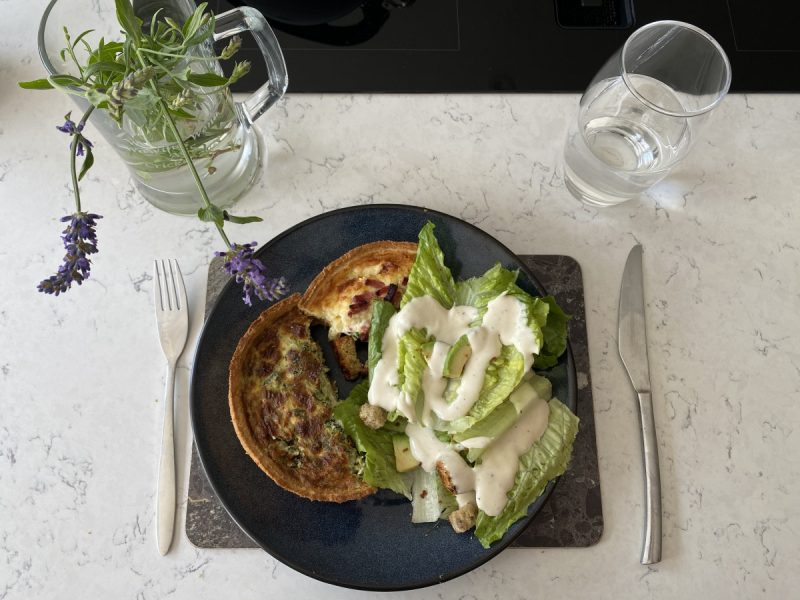 Photo of a prepared meal with quiche and salad on a plate