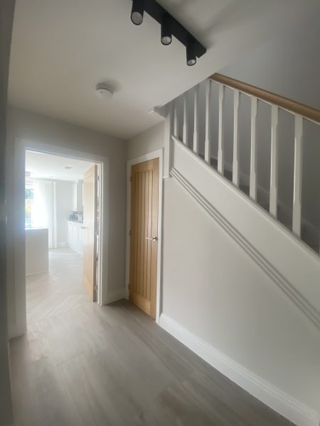 Photo of the downstairs passage area filled with light and leading into the kitchen