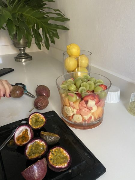 Photo of granadillas in front of a glass bowl of fruit salad