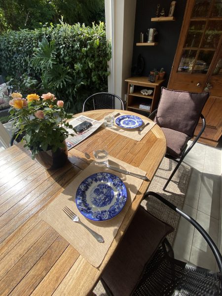 Table on a verandah set for a meal for two
